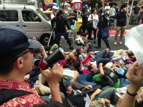 写真＝嫌韓デモに対し、路上に寝転んで抗議する人たち