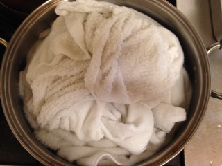 白い今治タオルとふきんを酸素系漂白剤を入れたお鍋で煮ている画像